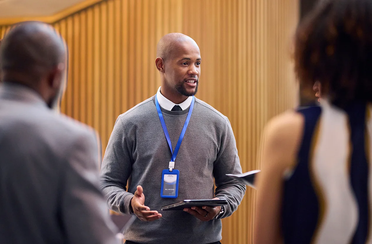 Man speaking to two people during or after a meeting