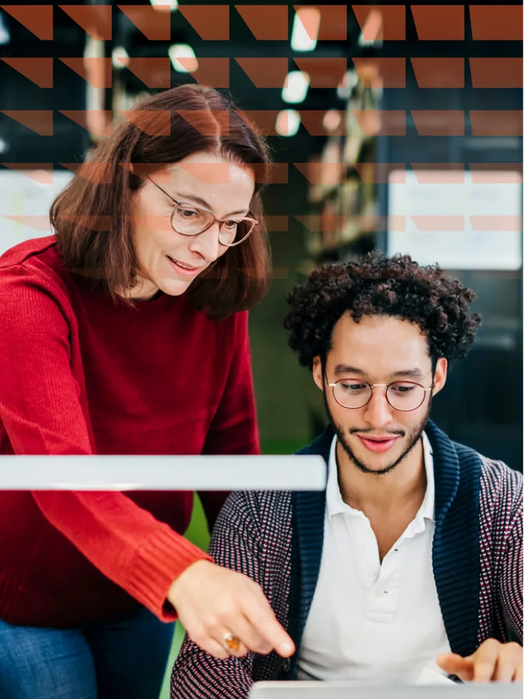 Woman helping a young man working in a library