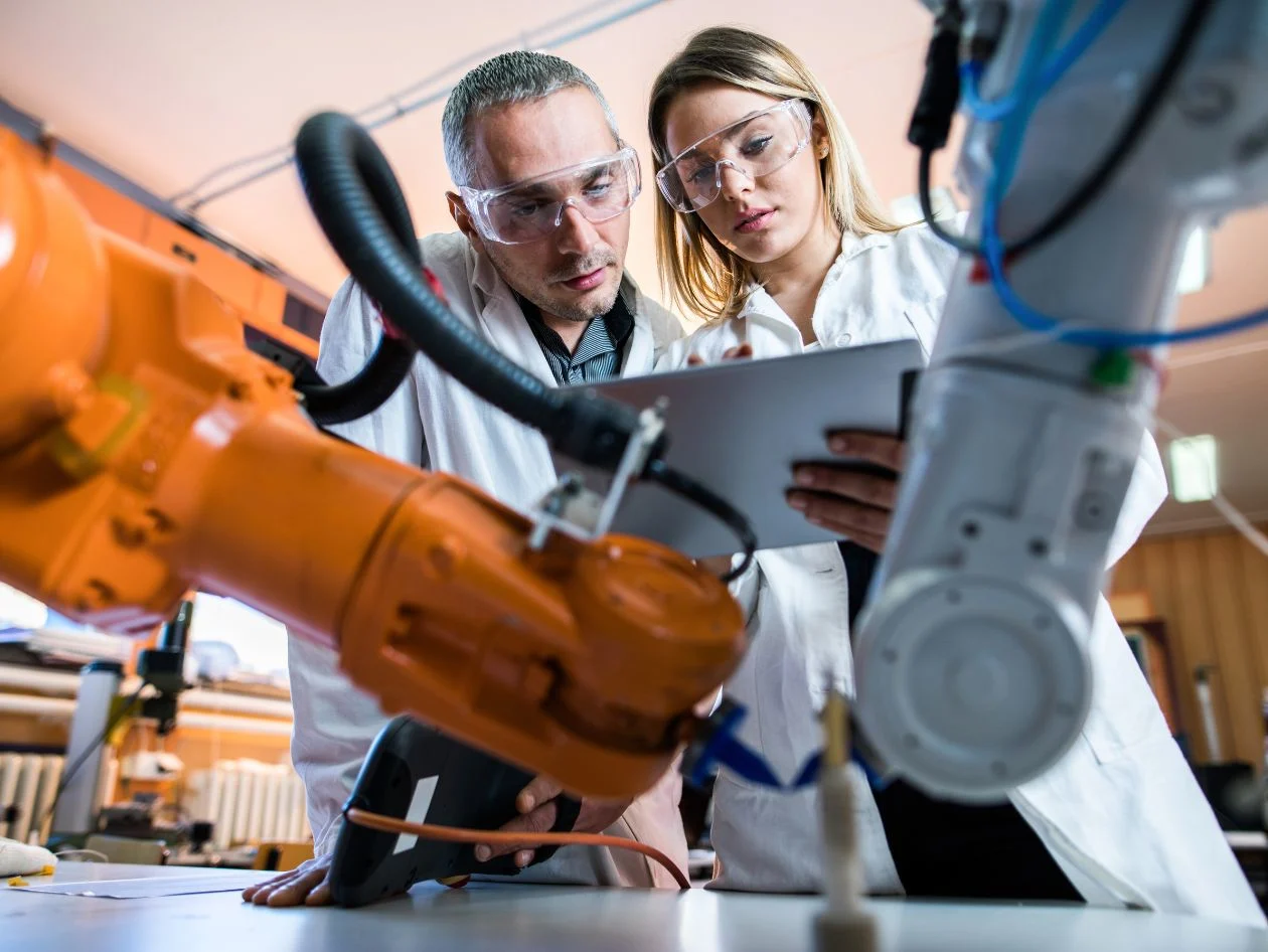 Two researchers collaborating on tablet in lab