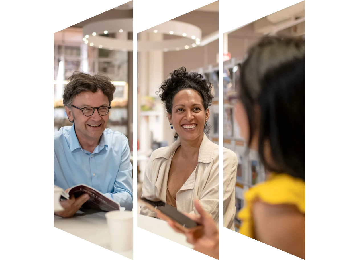 Two people smiling at a person who's head is turned away from the camera