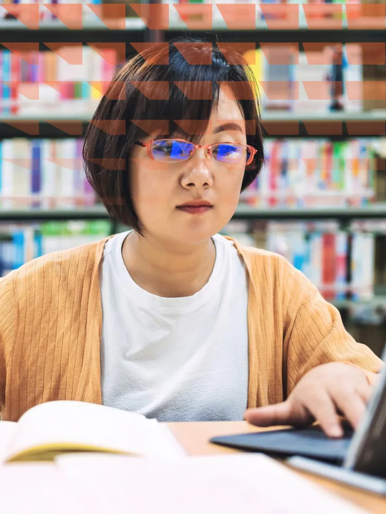 Asian woman using a laptop in a library
