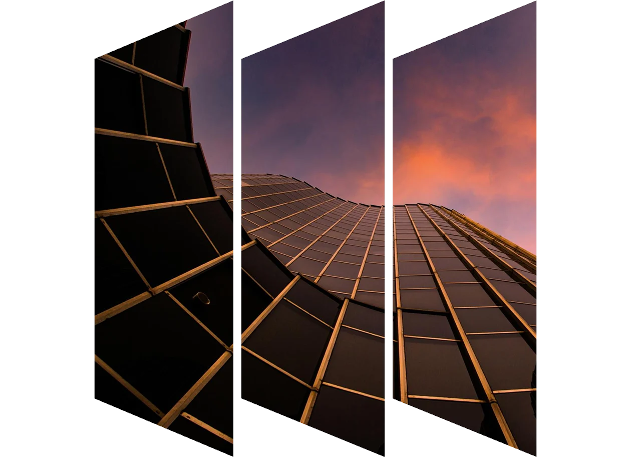 View of modern glass skyscrapers from below with a sunset sky