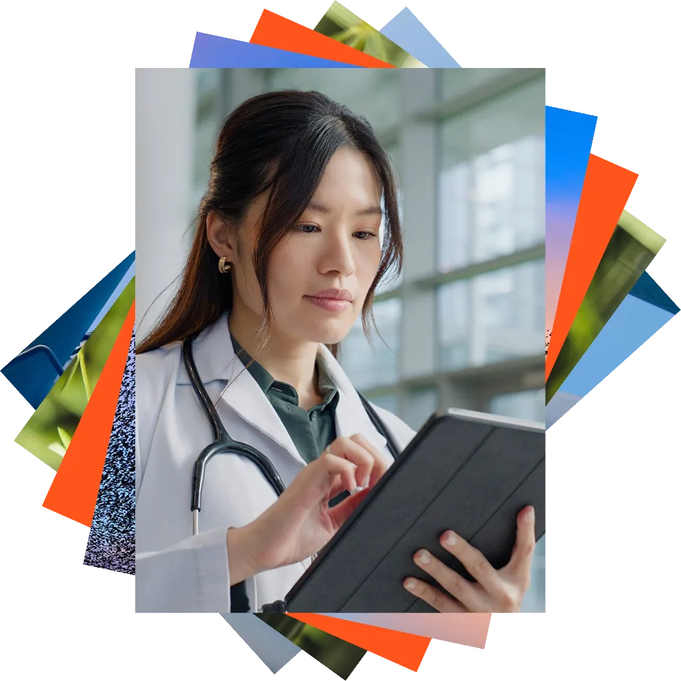 Female physician in a white coat with stethoscope looks at tablet.