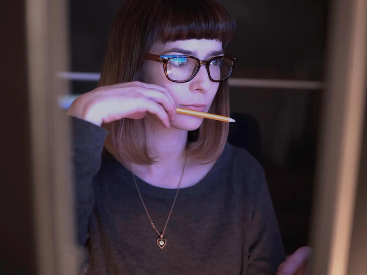 Young woman staring intently at computer monitor