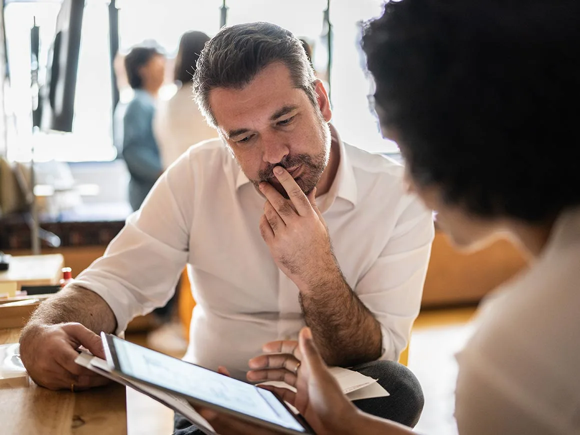 Man looking at tablet with colleague