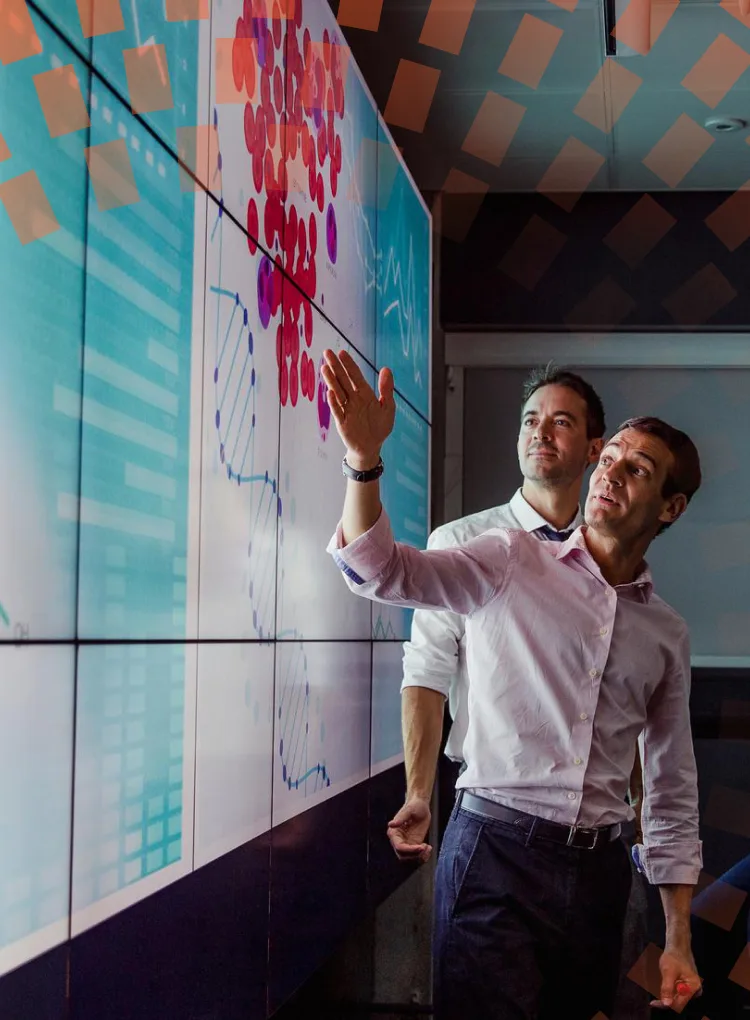 Group of adults viewing data on a large screen