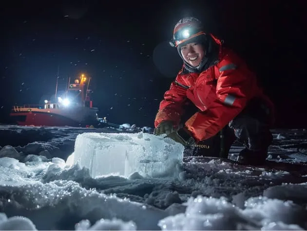 Asian man working on an ice patch in the artic