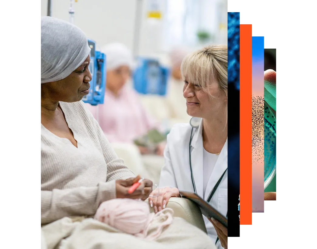 Female oncologist kneeling in front of a female patient in a cancer clinic