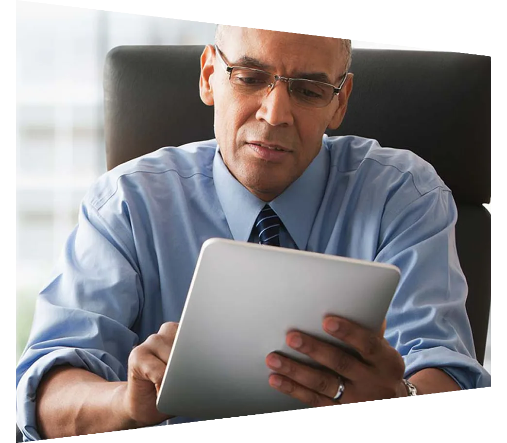 Businessman sitting in office chair looking at tablet