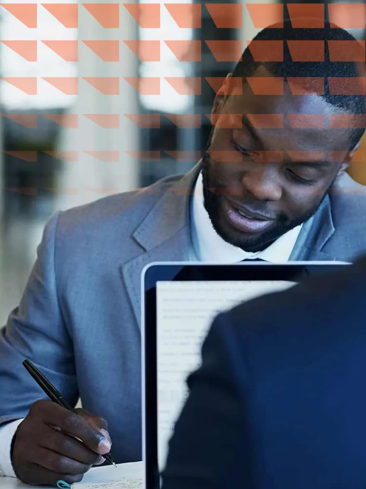 Man sitting at a desk signing documents