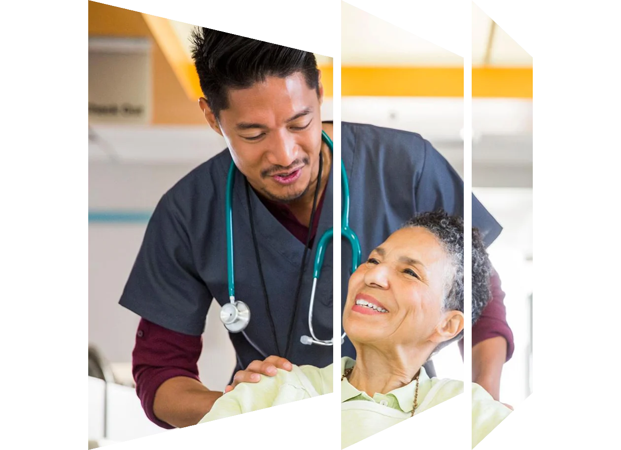 Male nurse pushing smiling senior woman in wheelchair