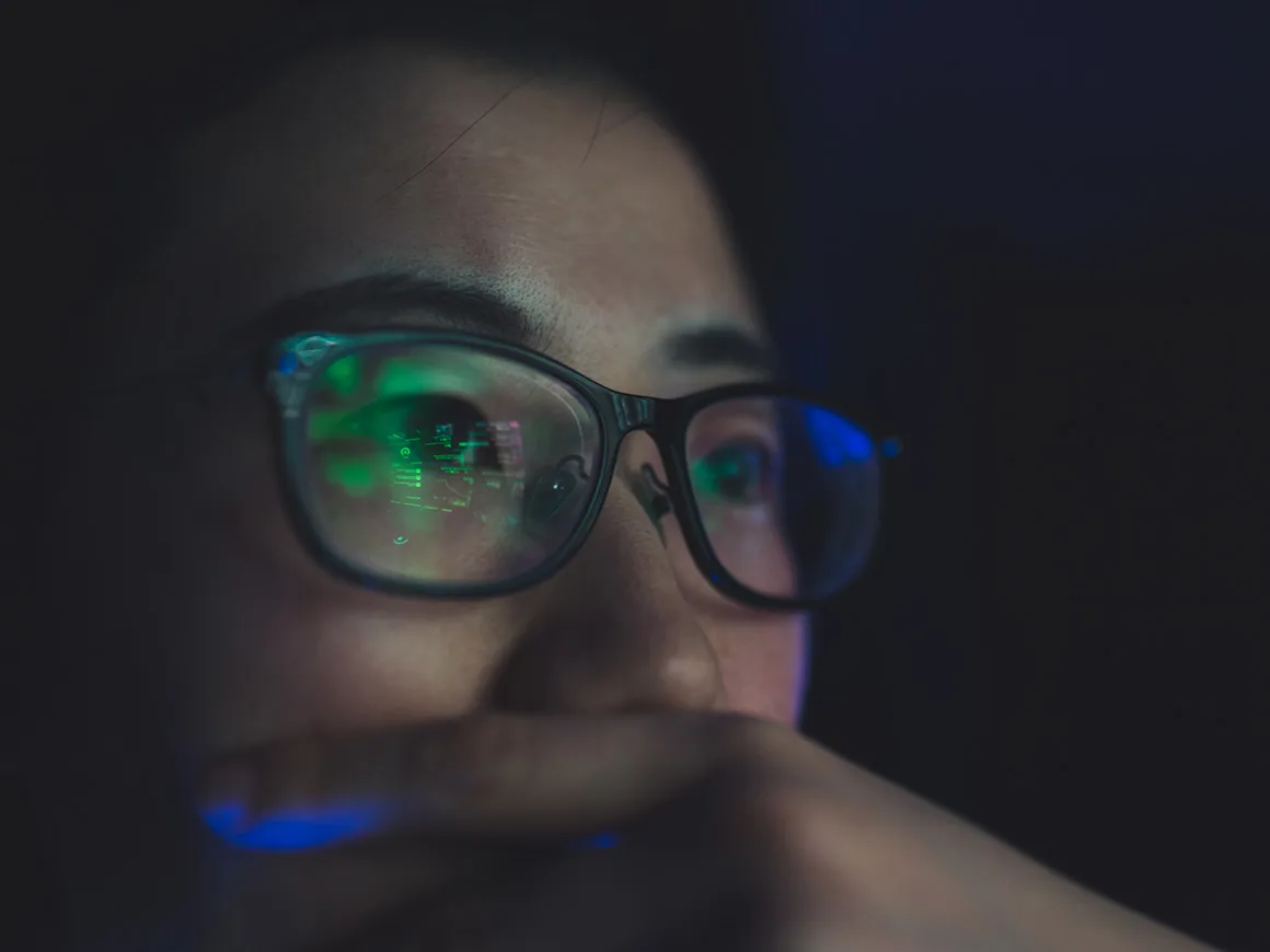 Mujer con pantalla de ordenador reflejada en las gafas
