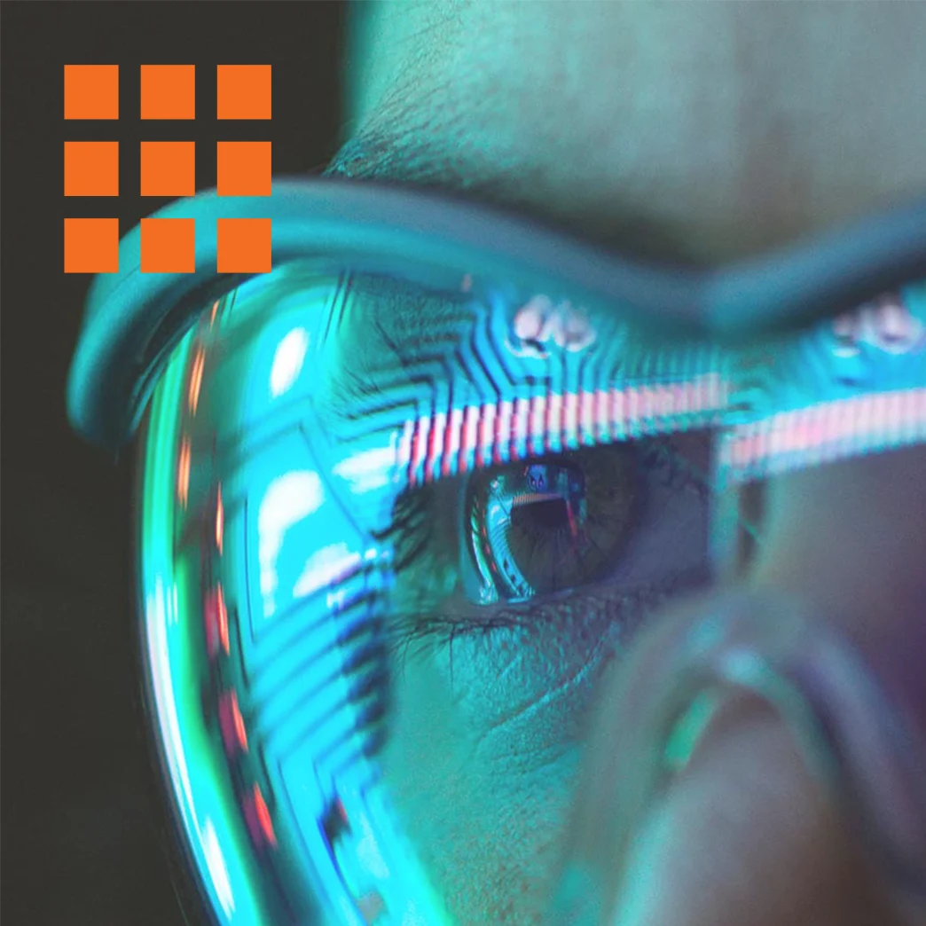 Close up image of a scientist in safety goggles examining data on a screen