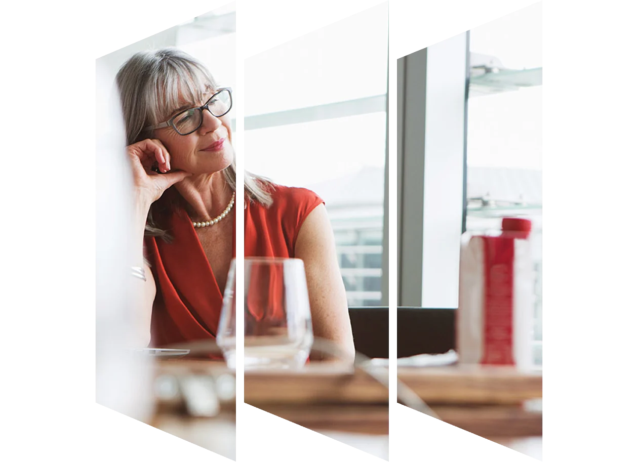 Professional woman looking out window sitting at conference table