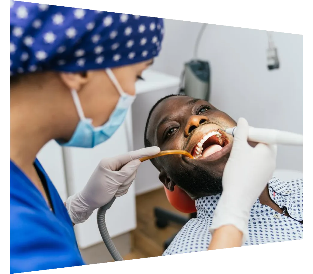 Dental assistant performing oral cleaning on a man