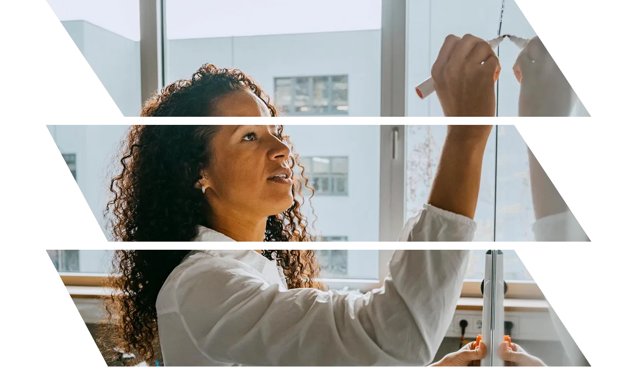 Side view of teacher writing on whiteboard with felt tip pen in classroom