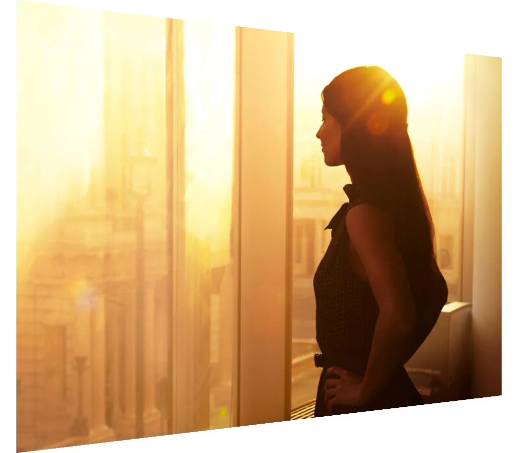 Business woman looking over the city at sunrise