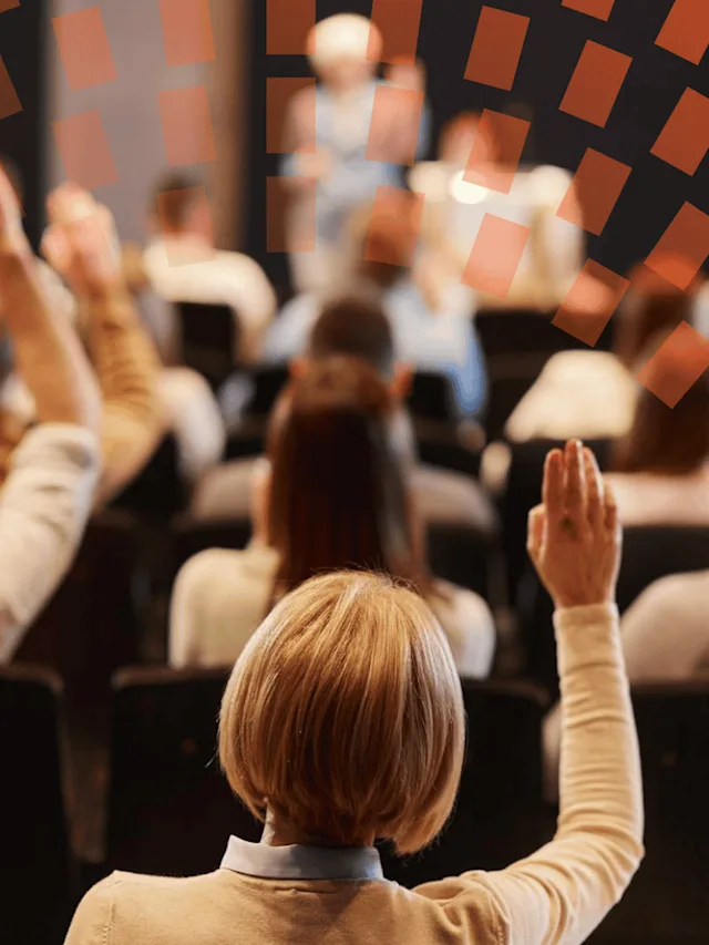Rear view of a raise hand up in a conference hall