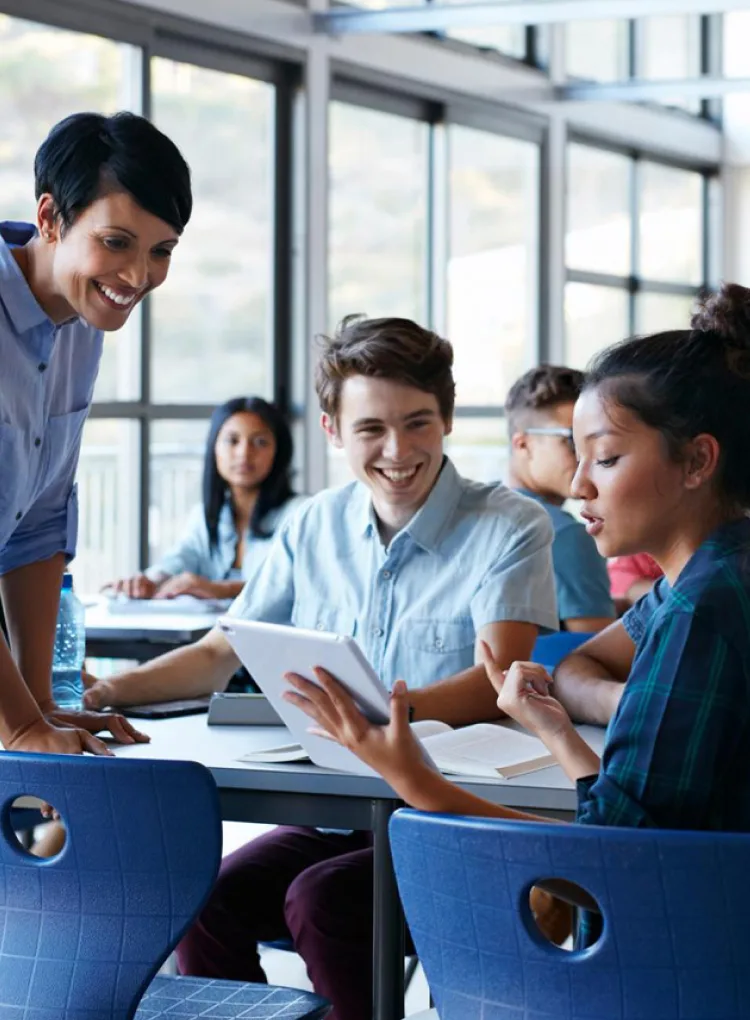 Teacher assisting group of students in a classroom