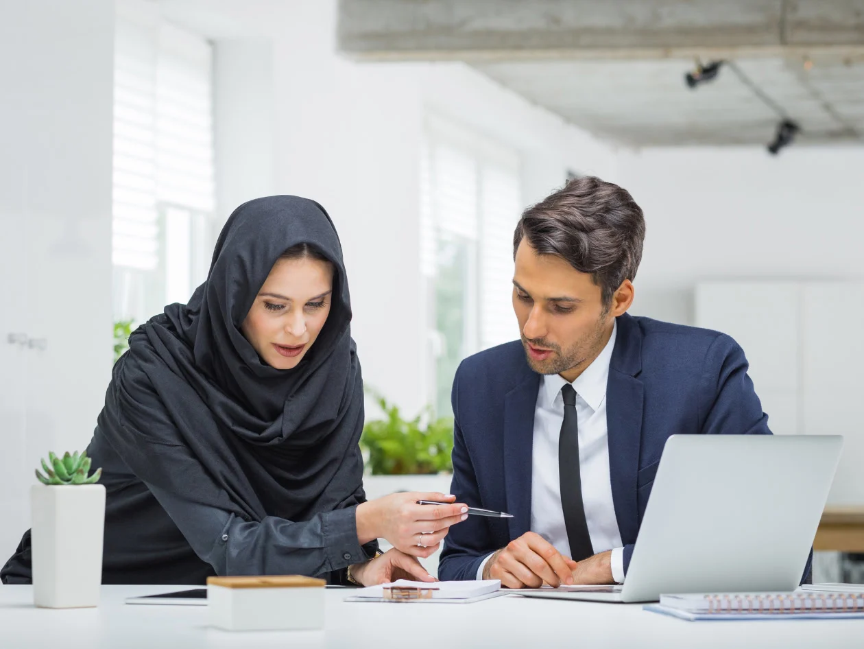 Man and woman with laptop and papers