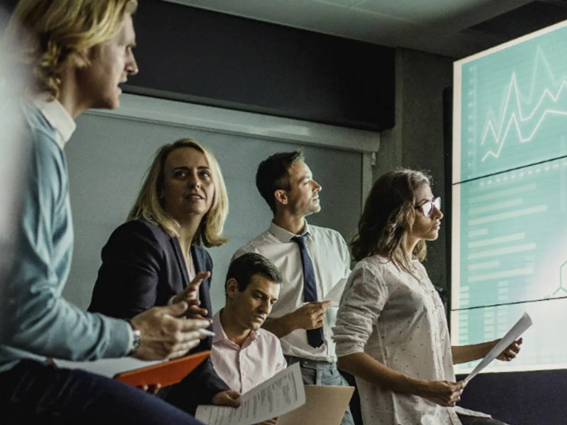 Professionals discussing data on a screen