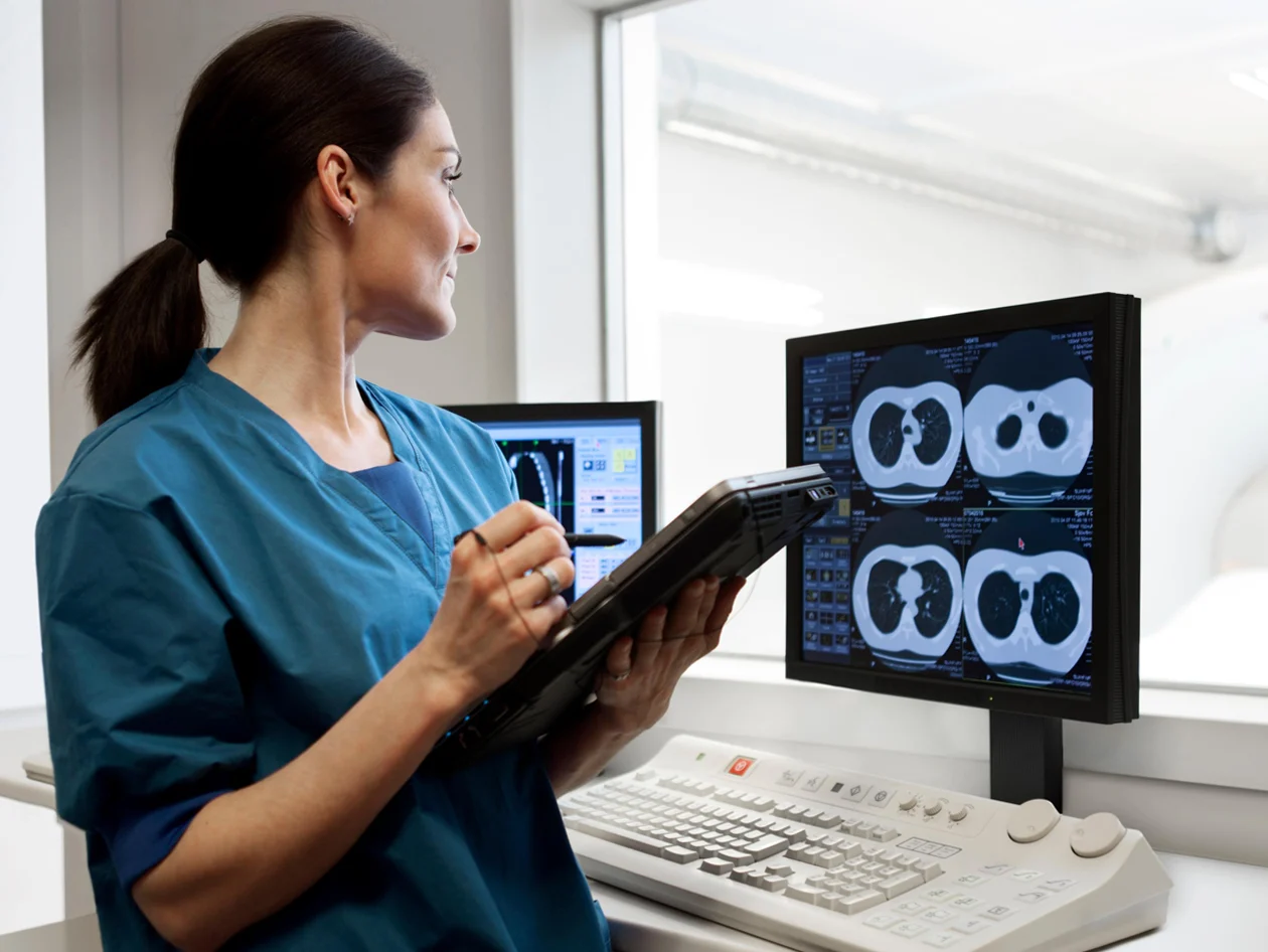Doctor standing by x-ray monitors with CT-scan images