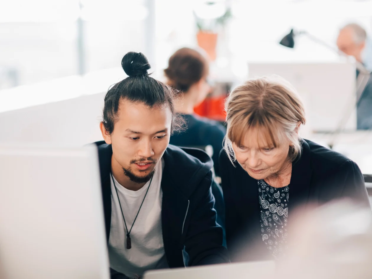 A man and a woman looking at a computer screen