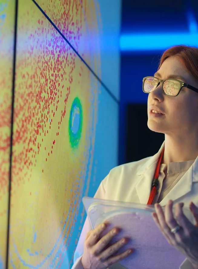 Scientist looking at data wall monitor