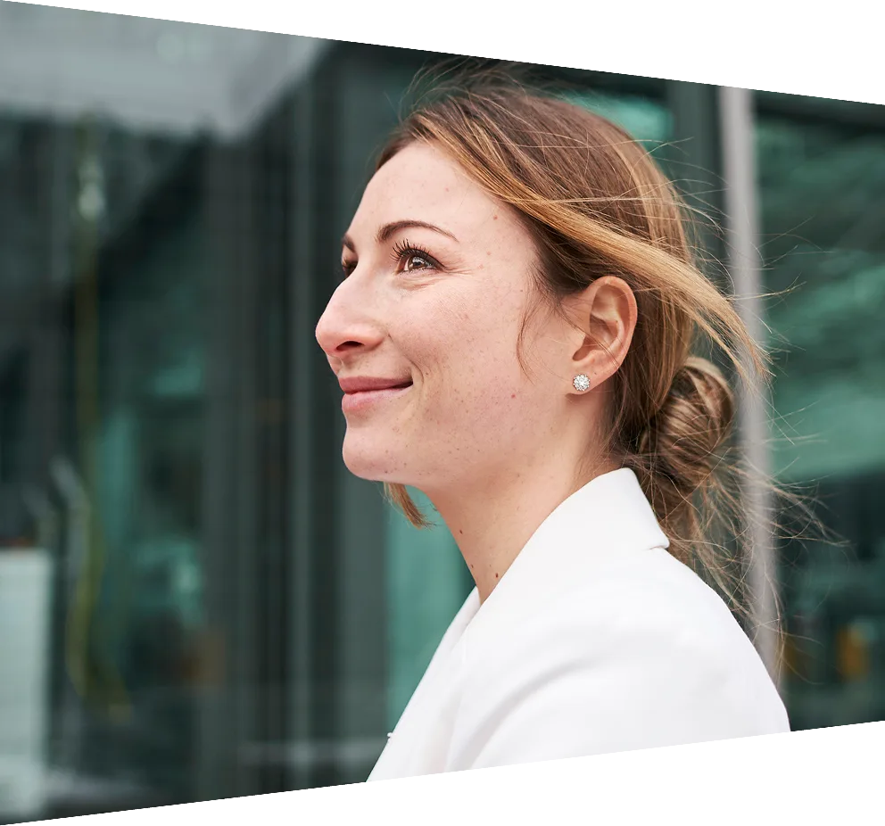 Smiling young businesswoman standing in front of a building