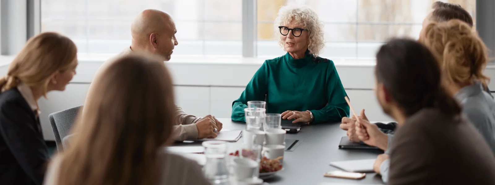 a group of people having a meeting on a desk