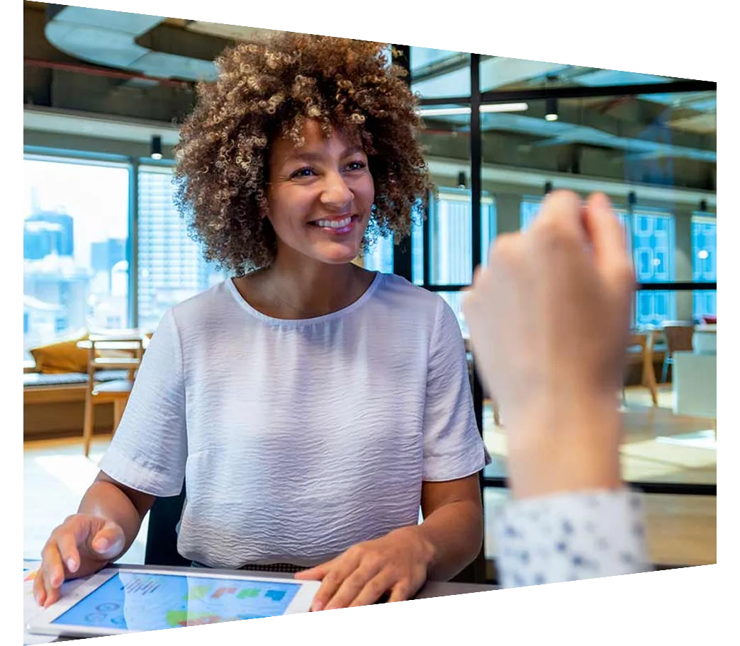 Smiling businesswoman with digital device talking to colleague