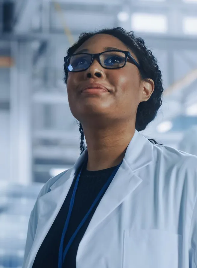 Female engineer looking around in wonder at aerospace satellite manufacturing facility