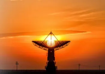 A satellite backlit by sunset 