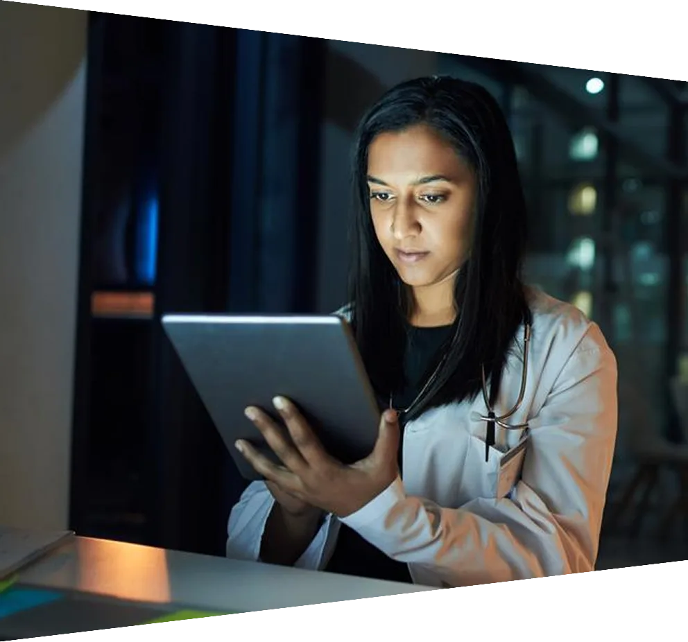 A young woman using her tablet at night