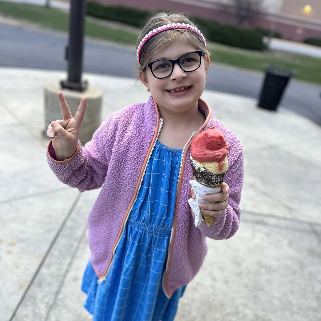 Girl with rare disease standing with ice cream cone