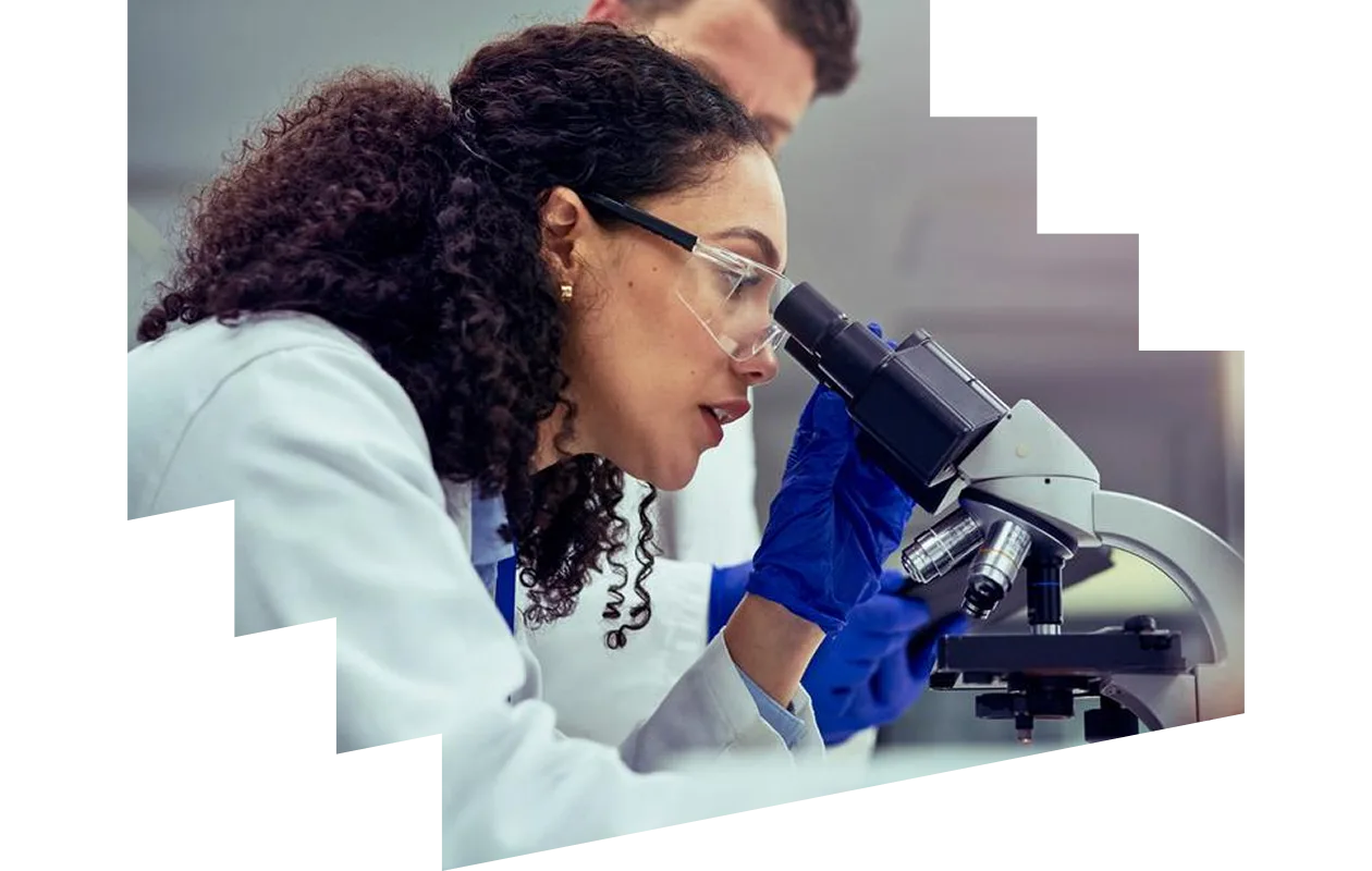 Male clinician looking through microscope