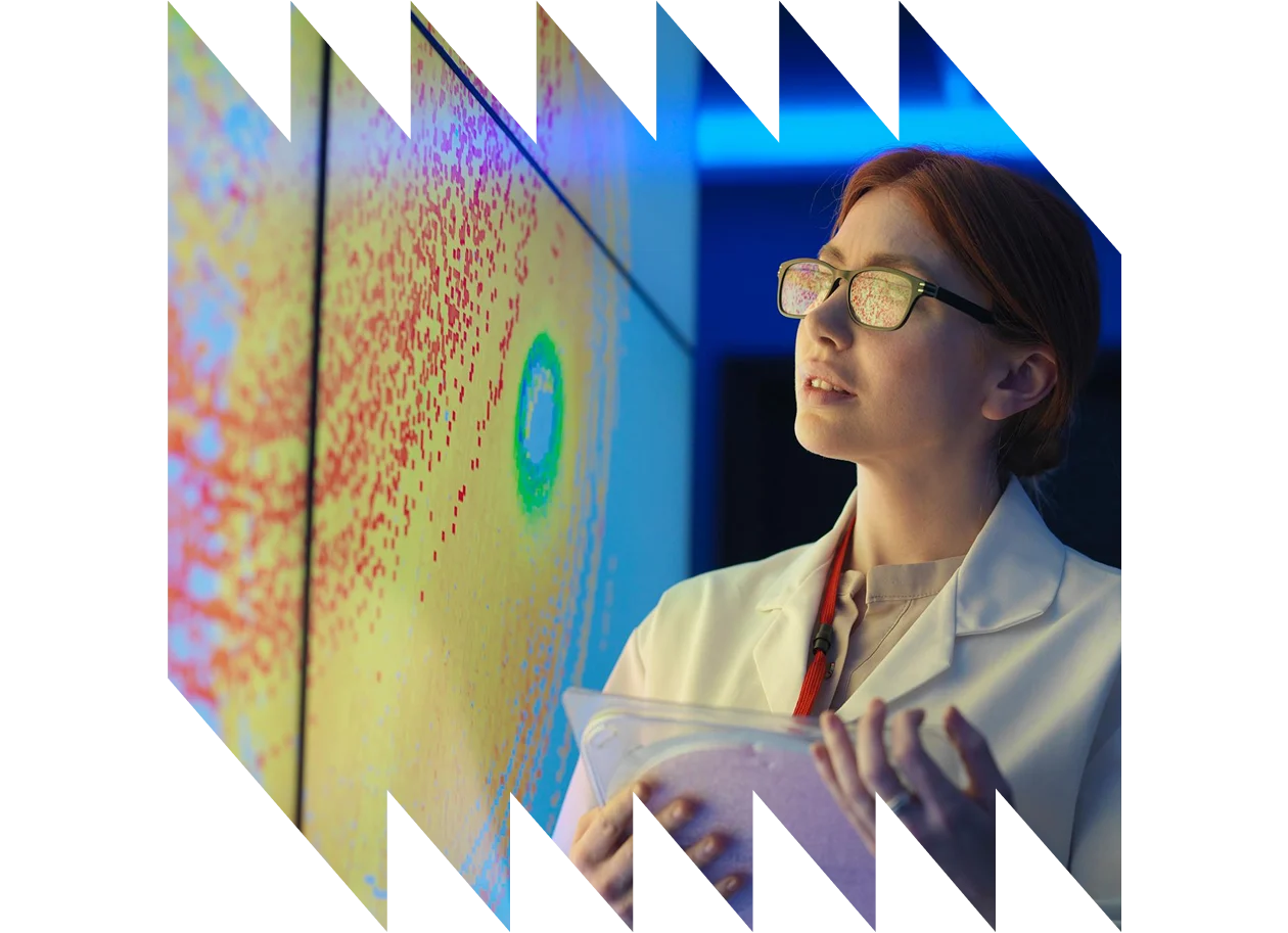 Female scientist with silicon wafer studying a graphical display of wafer on a screen
