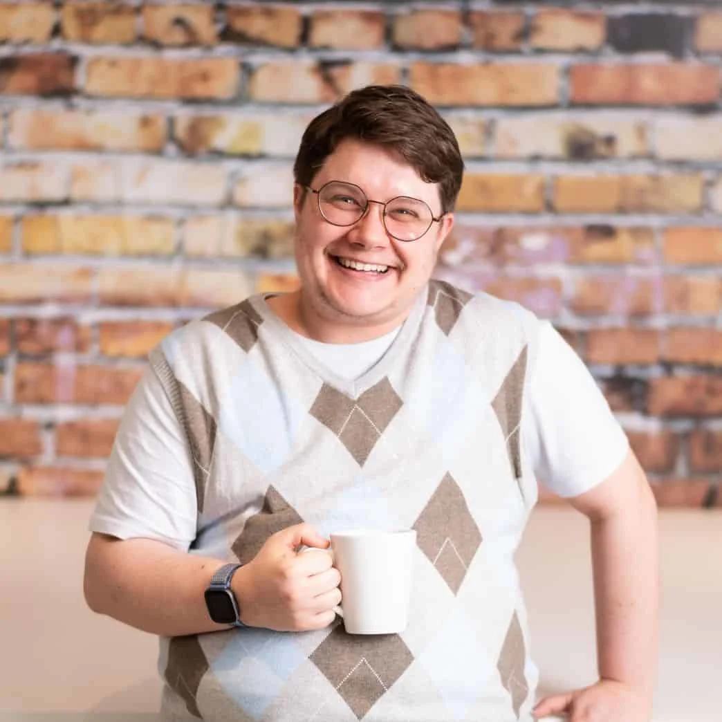 Elsevier Employee smiling and holding coffee in the office