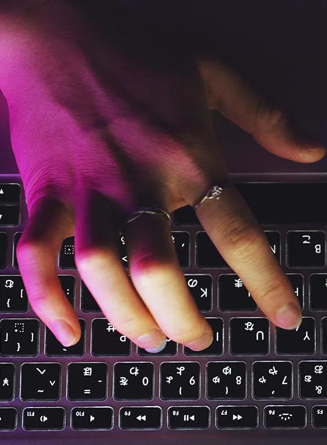 Top view of hands typing on laptop keyboard