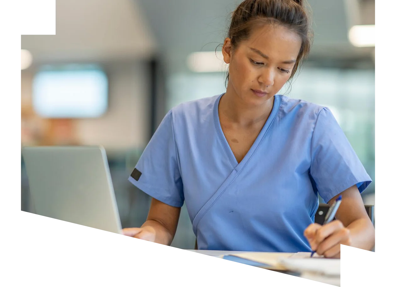 A nurse in scrubs is focused on accessing digital information in a healthcare setting