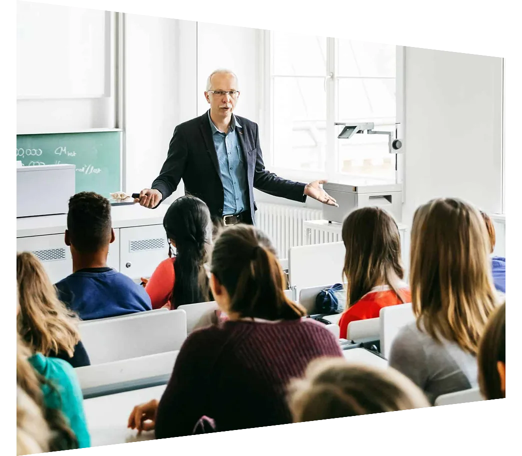 Back view of students in a classroom listening to a male lecturer