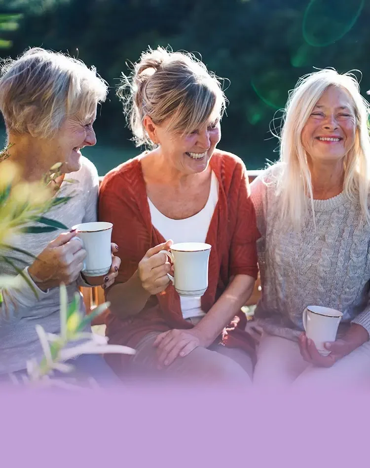 Trois femmes souriantes buvant du thé