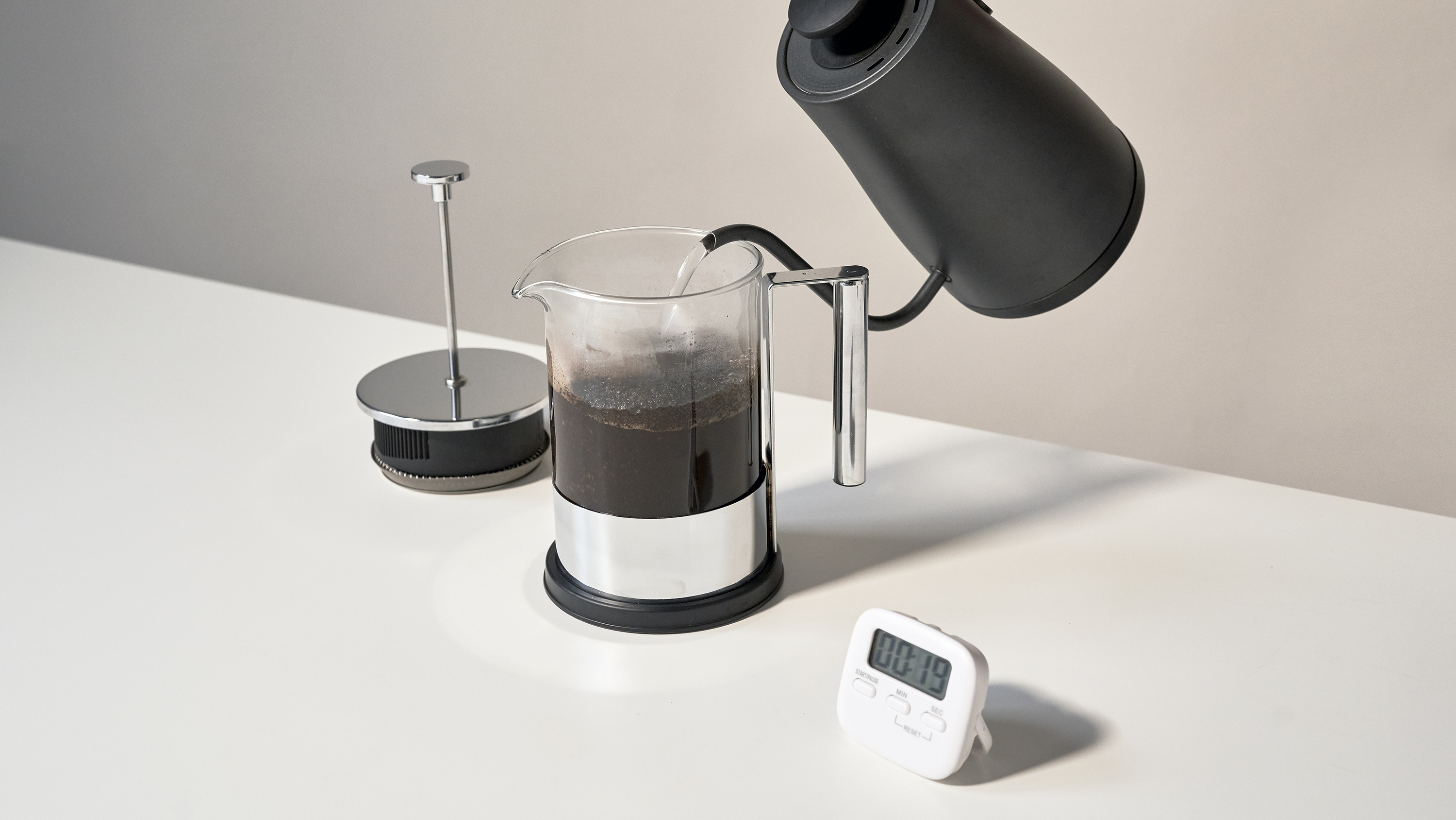 Making coffee with a French press, using a goose-neck kettle and a timer.