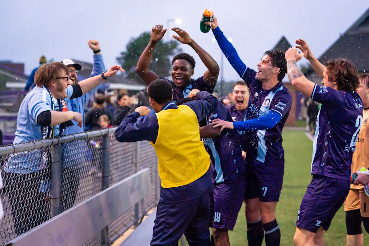 Celebrating with players after a come-from-behind victory against Lansing City on May 23, 2026