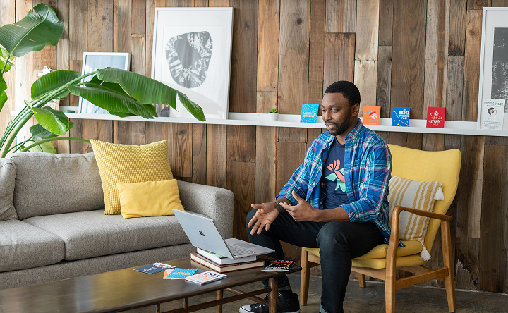 Person sitting on a couch using a laptop in a home setting