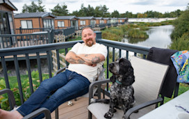 Dog with his owner on a caravan decking