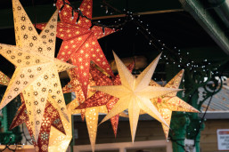 Festive lighting hangs from a Christmas market stall.