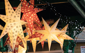 Festive lighting hangs from a Christmas market stall.