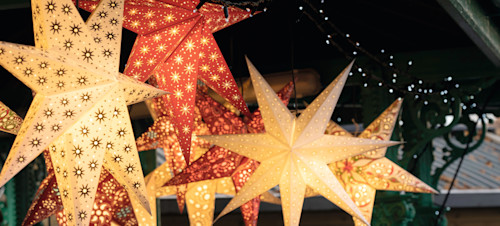 Festive lighting hangs from a Christmas market stall.