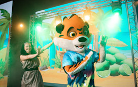 Rory - a Tiger mascot from the Seaside Squad - dances on stage with a Haven cast member.